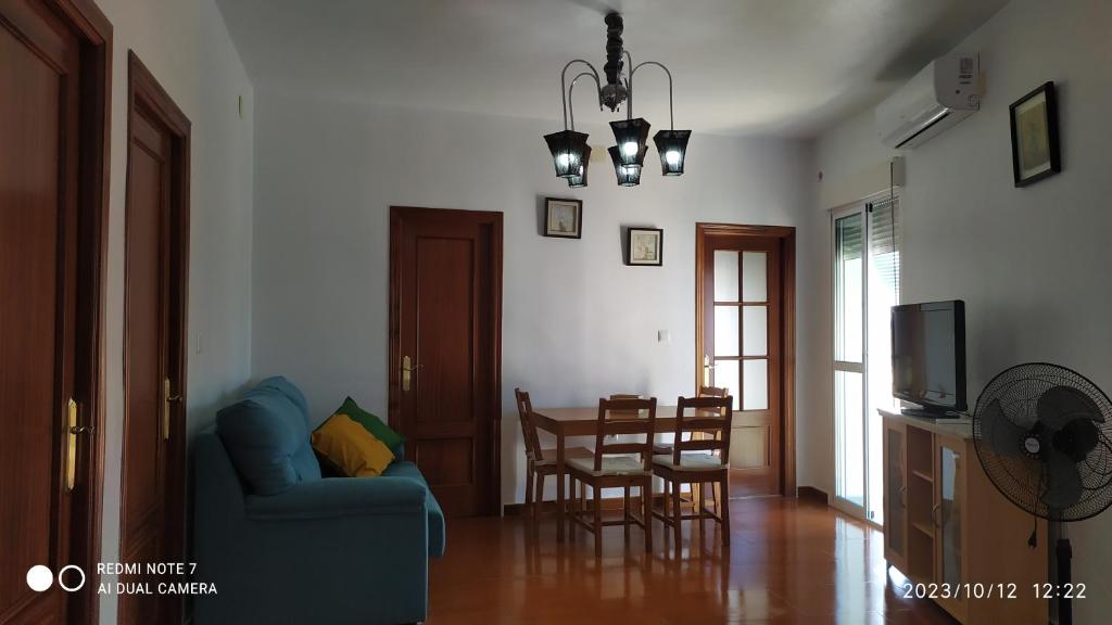 sala de estar con sofá azul y mesa en Apartamento Montiel, en Trigueros