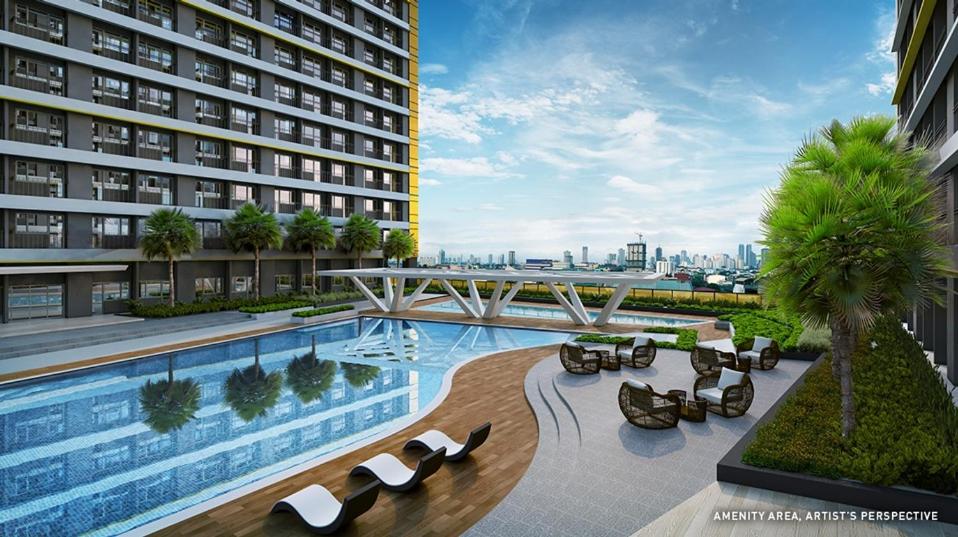 un hotel con piscina y un edificio en Fame Stays, en Manila