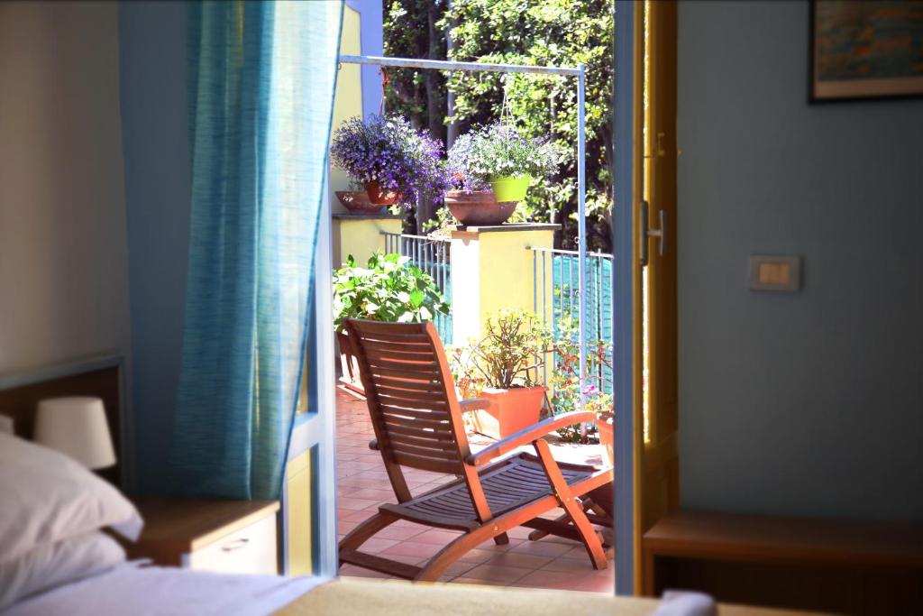 a wooden chair sitting on a balcony with potted plants at Solcalante in Procida