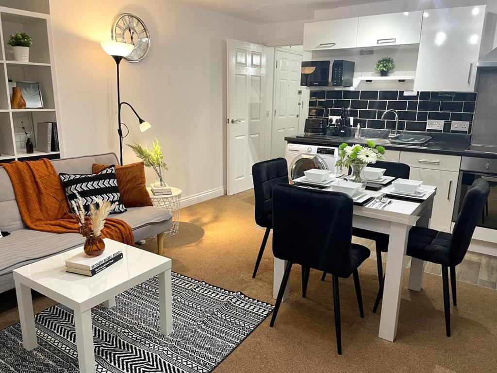 een keuken en een woonkamer met een tafel en een bank bij Stockwood Apartment by Cliftonvalley Apartments in Bristol