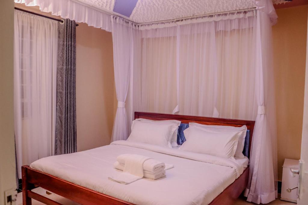 ナイロビにあるDayo Suites & Hotelのベッドルーム1室(ベッド1台、タオル2枚付)