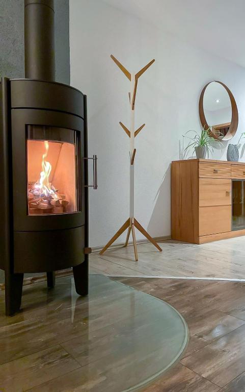 a fireplace in a living room with a wooden floor at Wohlfühloase in Eisenbach