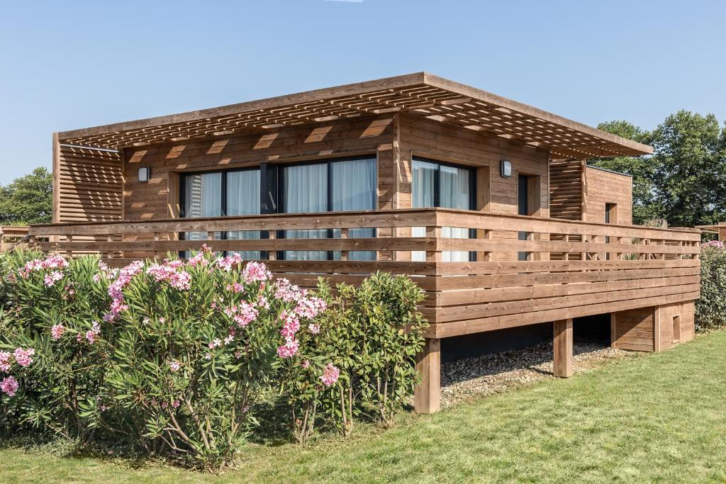 une maison avec une clôture et des fleurs devant elle dans l'établissement Résidence Pierre & Vacances Premium Domaine du Golfe du Lion, à Saint-Cyprien
