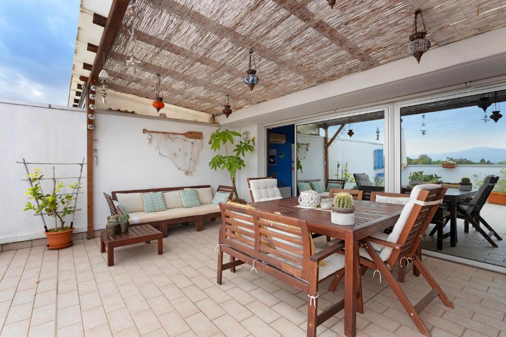 a patio with a table and chairs and a couch at Attico con terrazza a Viareggio in Viareggio