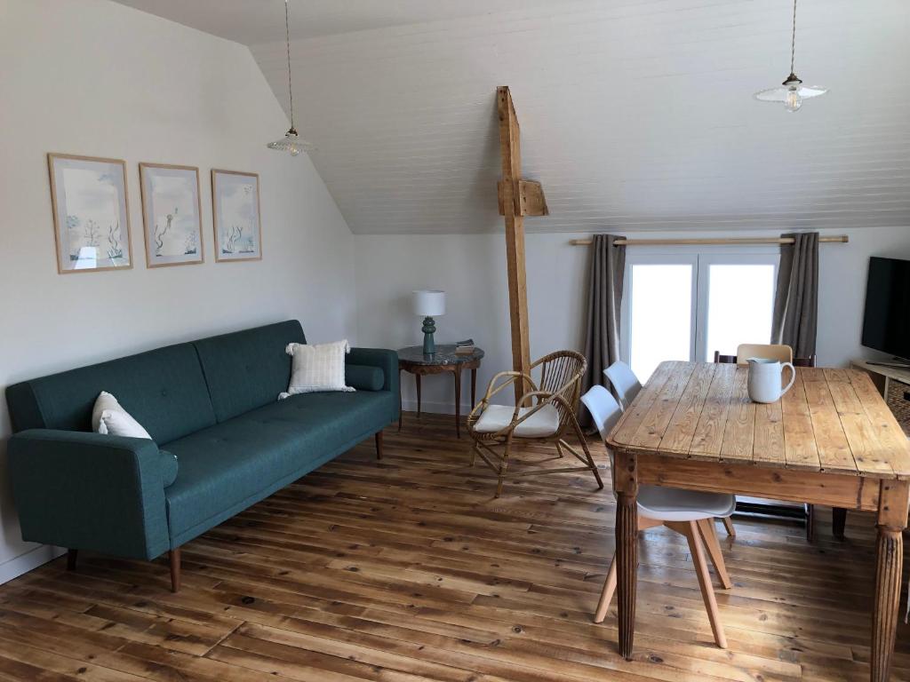 - un salon avec un canapé vert et une table en bois dans l'établissement Gite du Verger de Kerduel, à Moëlan-sur-Mer