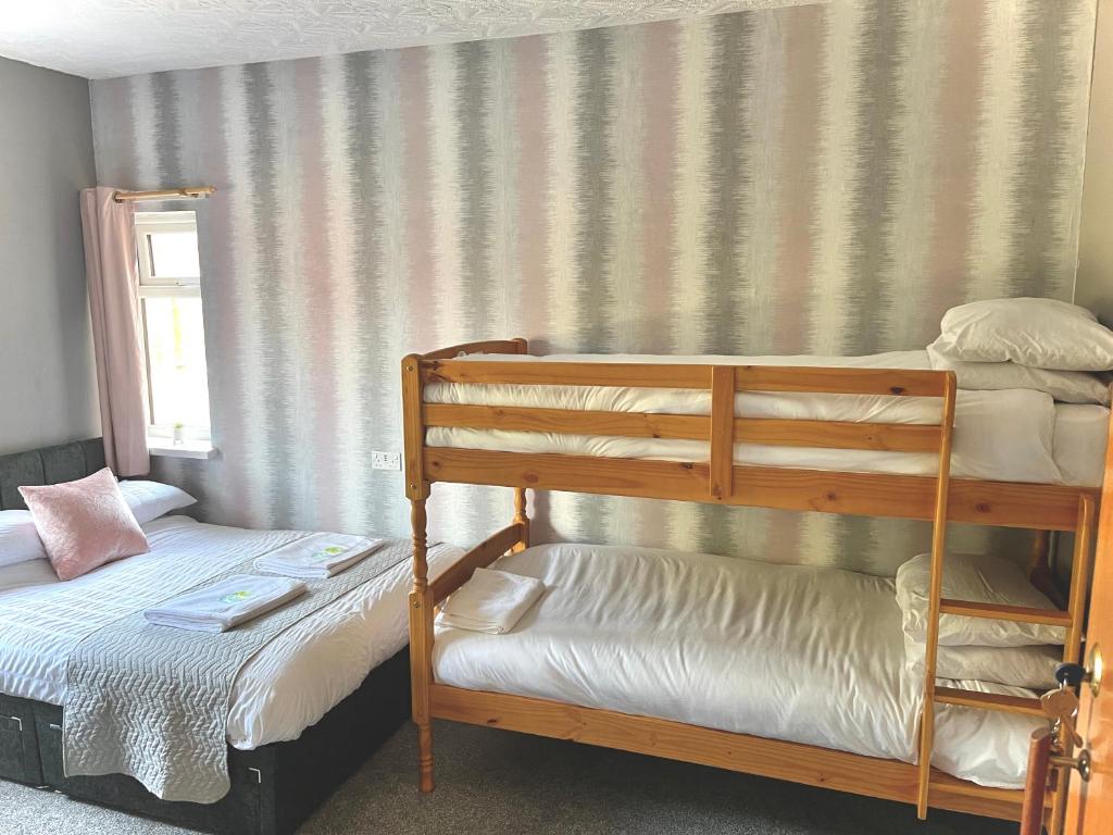 a bedroom with two bunk beds and a window at The Cresswell Inn in Skegness