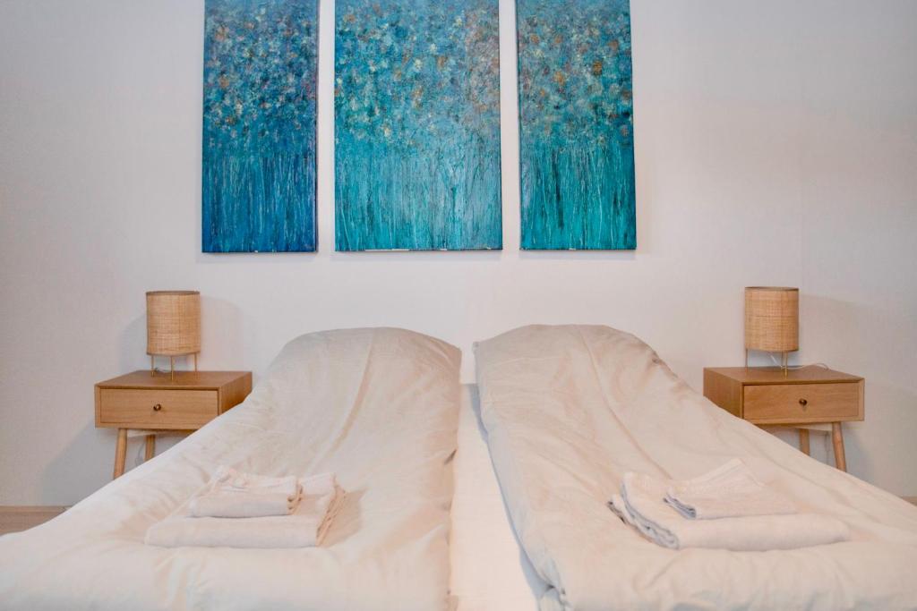 um quarto com uma cama com duas mesas e dois quadros em Apartment in Sørvágur em Sorvágur