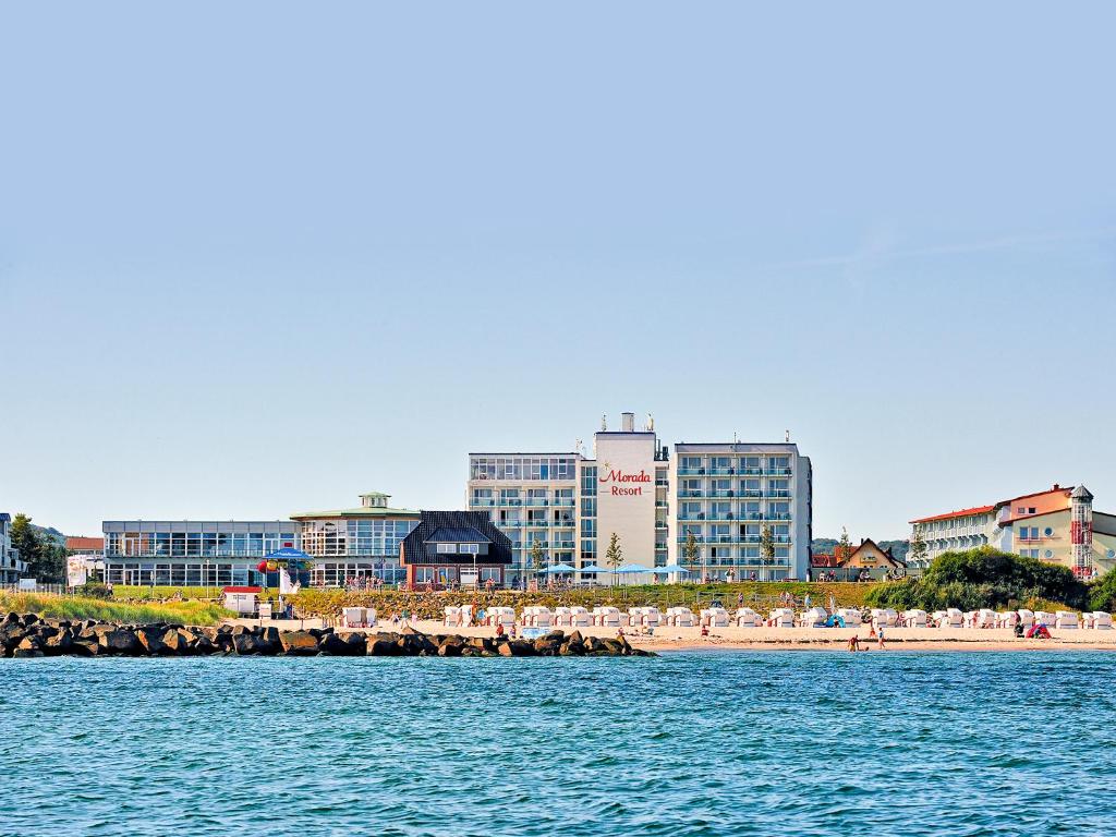 una spiaggia con alcune sedie e alcuni edifici e l'acqua di Morada Resort Kühlungsborn a Kühlungsborn