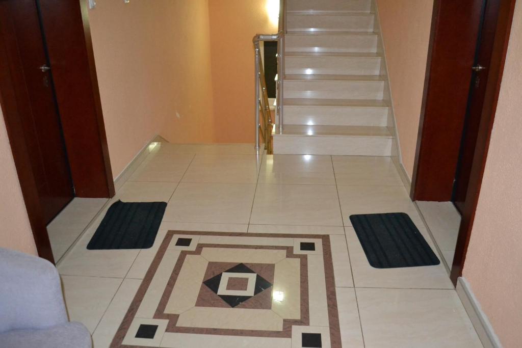 a hallway with a staircase with a tile floor at Apartments Elizabet in Star Dojran