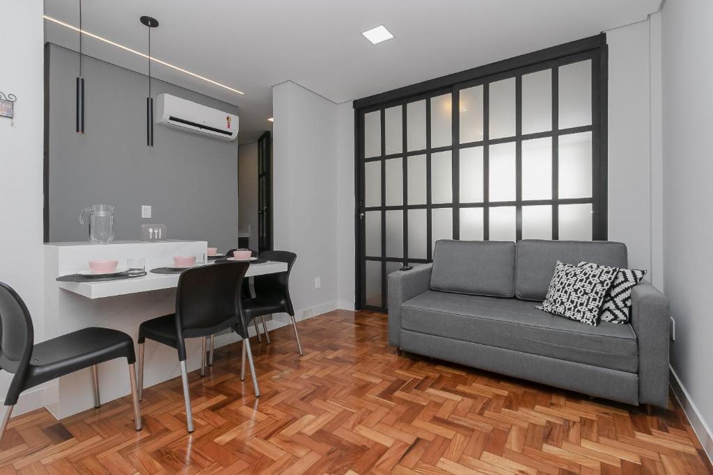 ein Wohnzimmer mit einem Sofa und einem Tisch in der Unterkunft Apto 2 quartos no Centro de BH in Belo Horizonte
