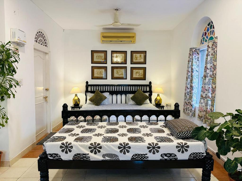 een slaapkamer met een zwart-wit bed en 2 ramen bij Anandmai Heritage Homestay in Jaipur