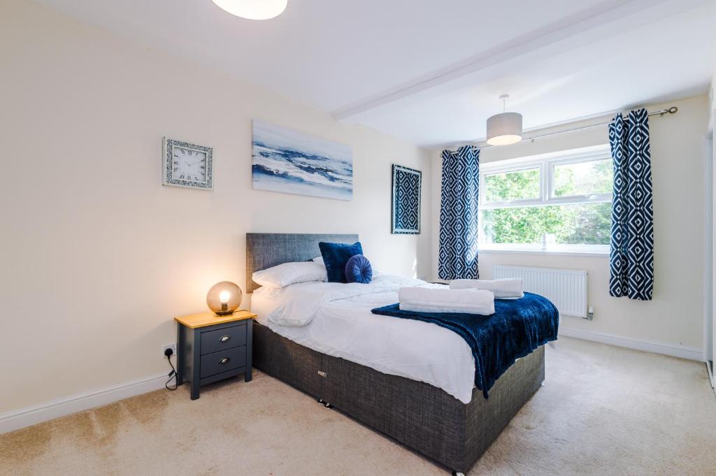 a bedroom with a large bed and a window at 5 bed detached - Worsley, Manchester in Worsley