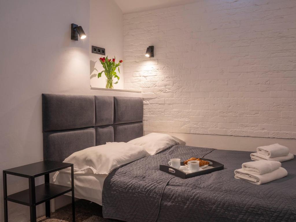 Zimmer mit einem Bett und einem Tablett mit Essen darauf in der Unterkunft New World St Hostel and Private Room in Warschau