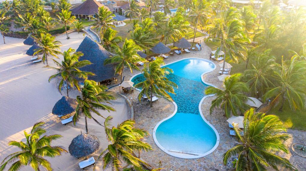 an aerial view of a resort pool with palm trees at Ocean Beach Resort & SPA in Malindi