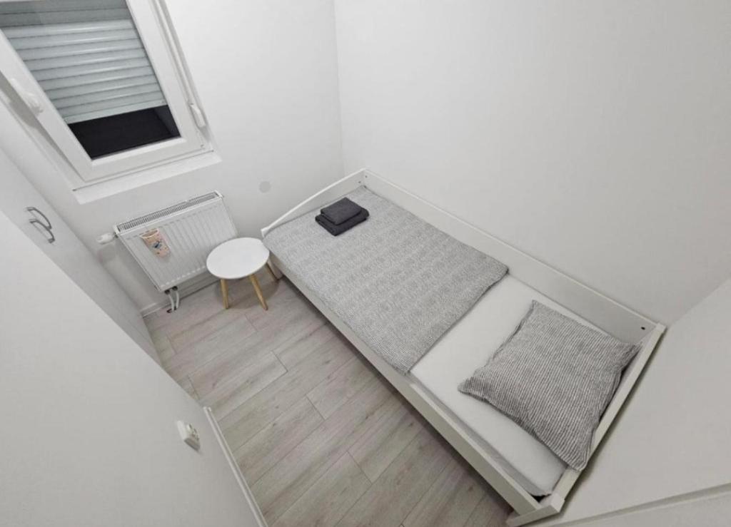 Cette petite chambre comprend un lit et une table. dans l'établissement Lamia, à Osijek