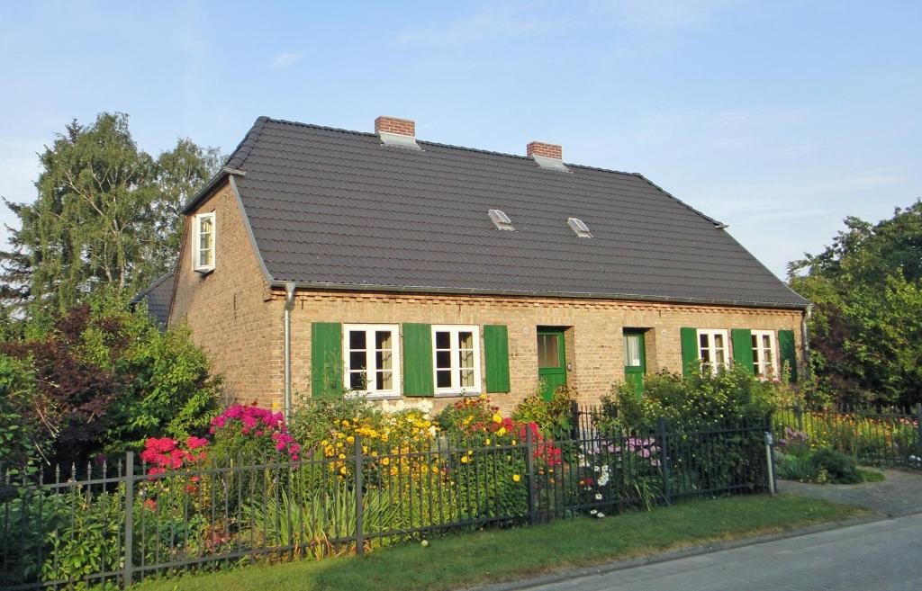 ein Haus mit einem schwarzen Dach und einem Zaun in der Unterkunft Ostsee-Kate in Schmatzin