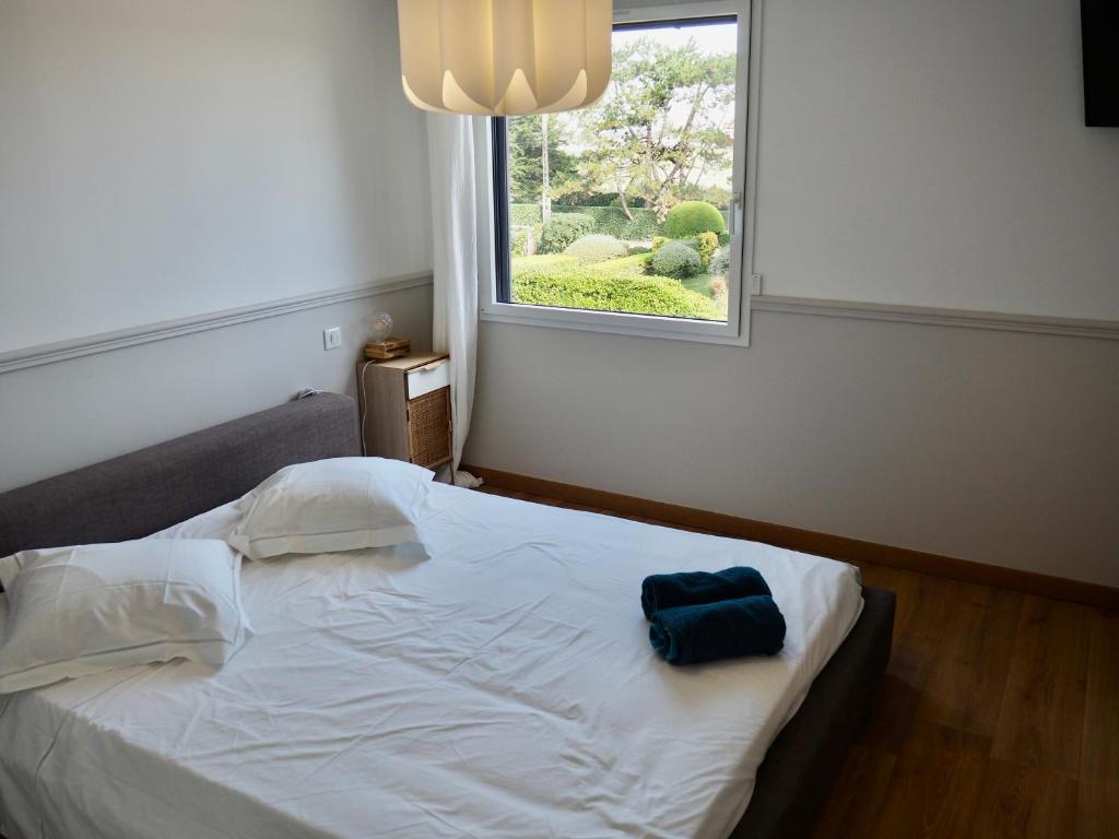 een slaapkamer met een wit bed met een raam bij Villa de prestige vue sur Baie de Canche in Le Touquet-Paris-Plage
