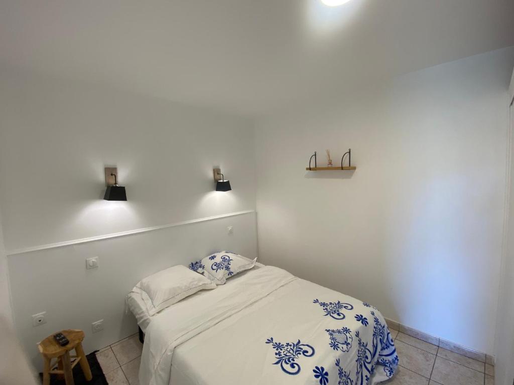 - une chambre avec un lit et deux lumières sur le mur dans l'établissement Chez k - Studio - Proche Centre - Parking, à Sainte-Savine