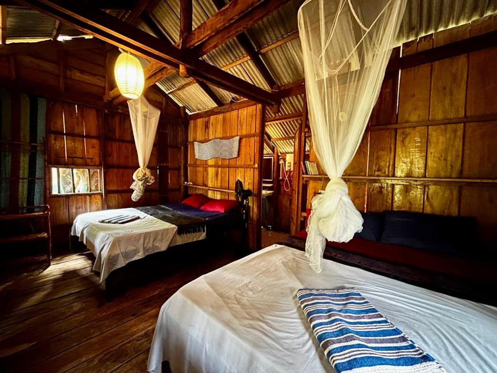 1 dormitorio con 2 camas en una cabaña de madera en Easy Tiger Garden Bungalows - by Beach House Cambodia, en Koh Rong Sanloem
