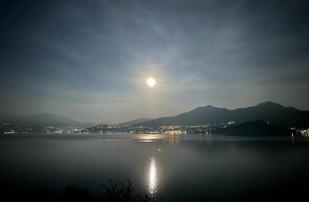 una vista de un lago por la noche con la luna en Bella Vista sul Lago Maggiore, en Ghiffa