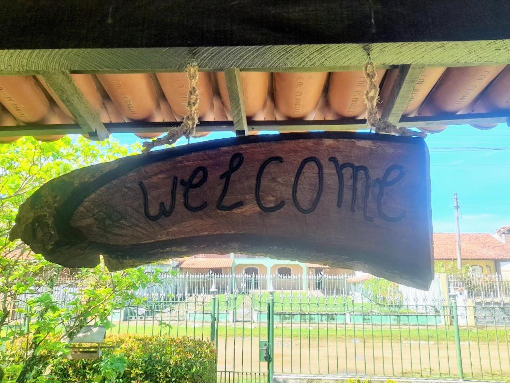 een teken dat zegt welkom hangend aan een veranda bij Cantinho da Lagoa in Araruama