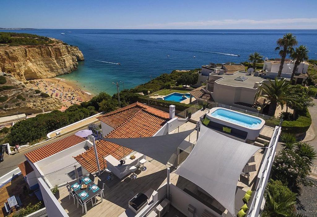 uma vista aérea de uma casa com piscina em Villa Benagil with stunning views and roof terrace with private heated pool em Lagoa