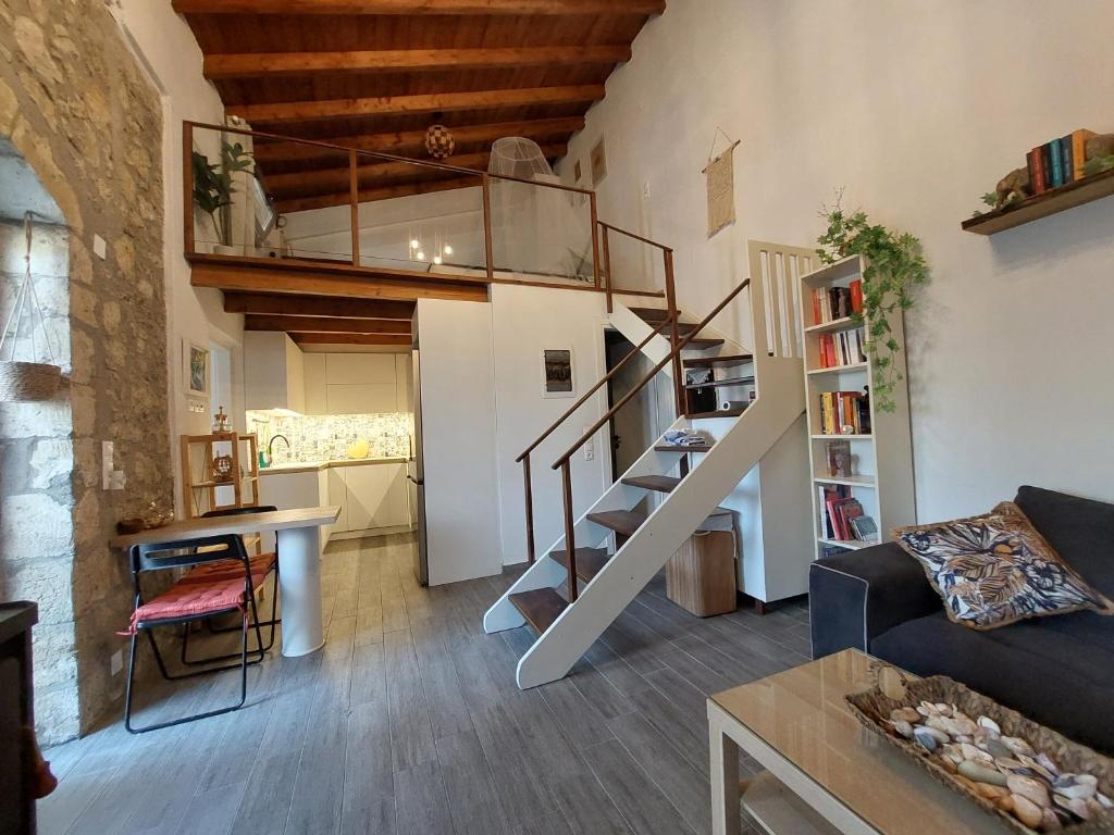 a living room with a spiral staircase in a loft at Cueva Atlantis in Stamnoí