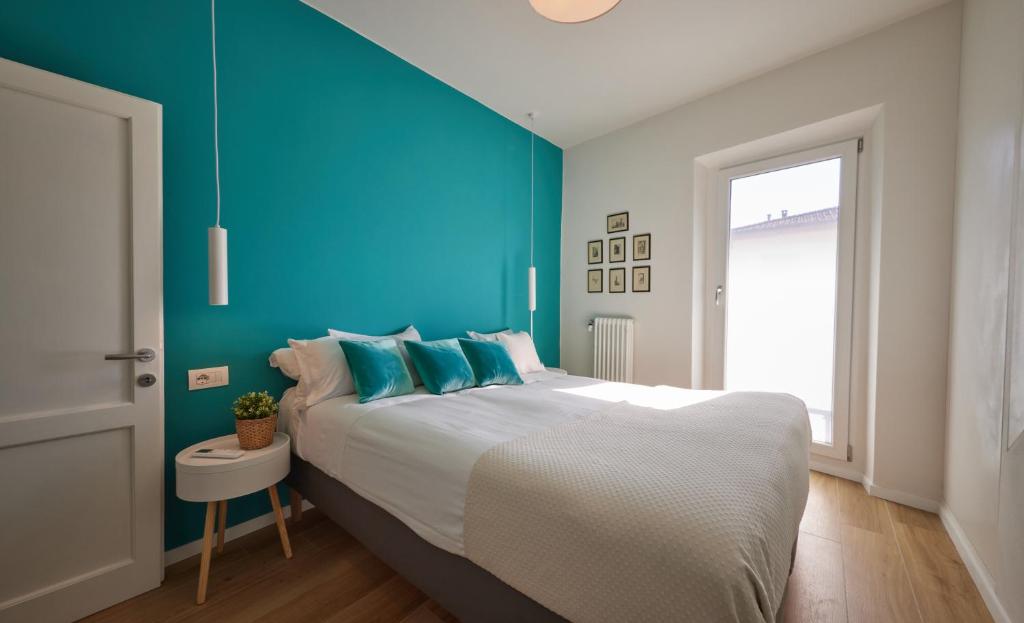 ein Schlafzimmer mit einem großen Bett mit blauer Wand in der Unterkunft Torregalli- Terrace Apartment in Florenz