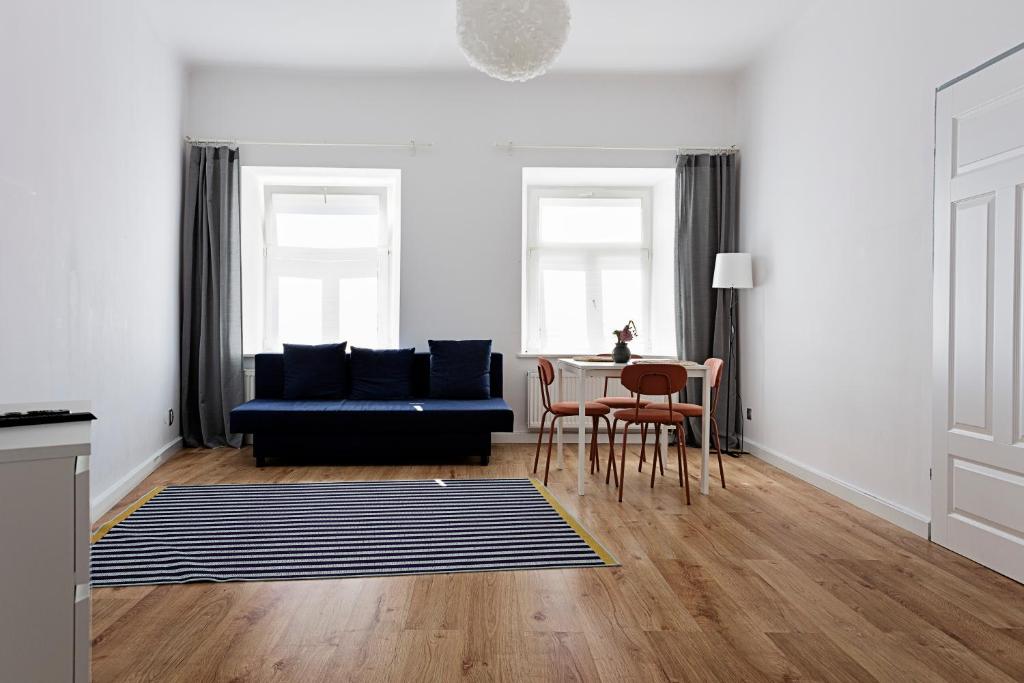 a living room with a blue couch and a table at Apartamenty Krakowskie Przedmieście nr 9 in Lublin