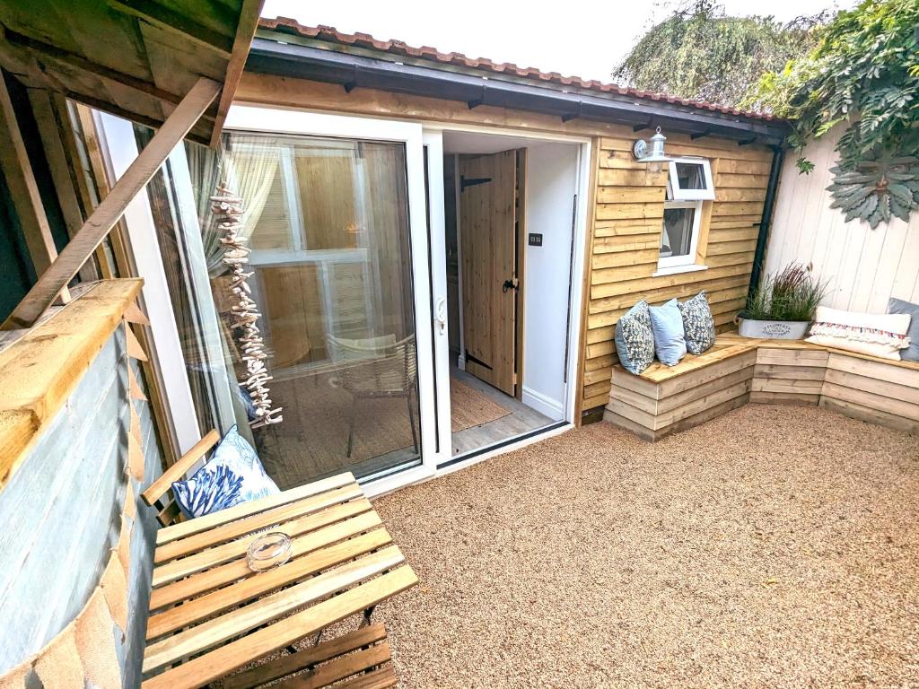 a sliding glass door on a shed with a bench at La Cachette in Blackpool