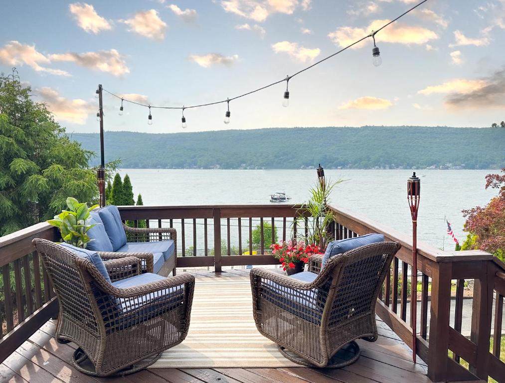 a deck with chairs and a view of the water at Cozy Lakeside Fall Escape; Applepick, Hike, Winery in Greenwood Lake