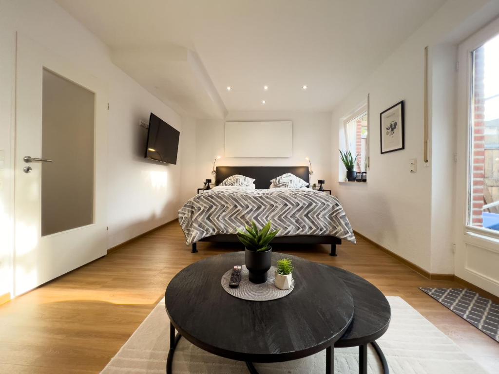 ein Schlafzimmer mit einem Bett und einem Tisch davor in der Unterkunft Zentrales Apartment für 2 *Bogenstraße* in Norderney