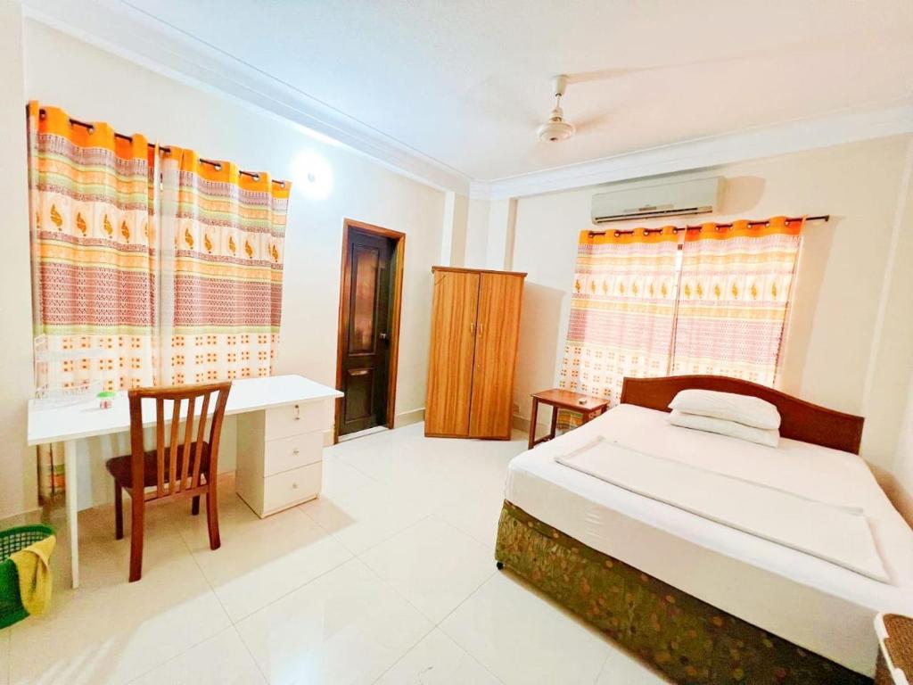 - une chambre avec un lit et un bureau dans l'établissement Maya Eco Apartment Service, à Dhaka