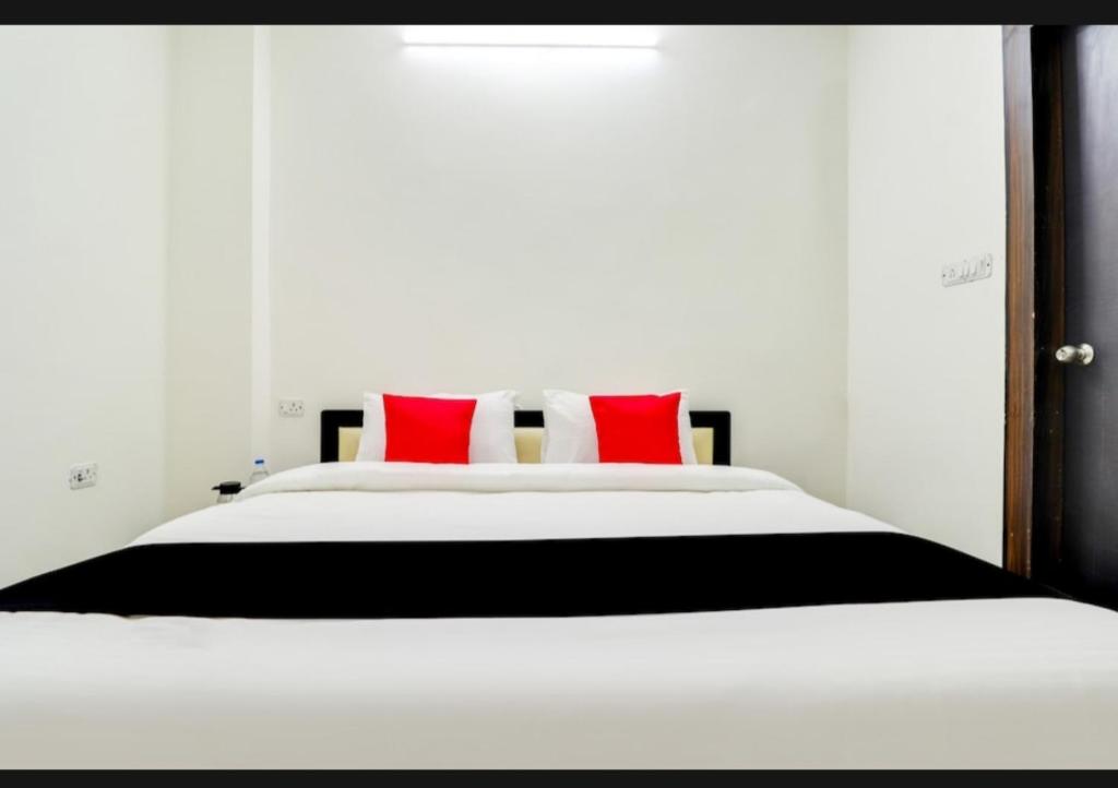 a bedroom with a large white bed with red pillows at Nilansh homes and hotels in Lucknow