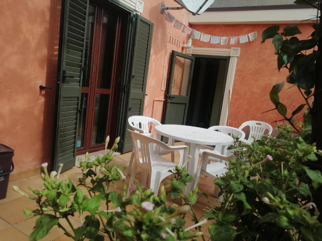 Casa con giardino a due passi dal mare في روزيتو ديلي أبروتسي: طاولة بيضاء وكراسي بيضاء على الفناء