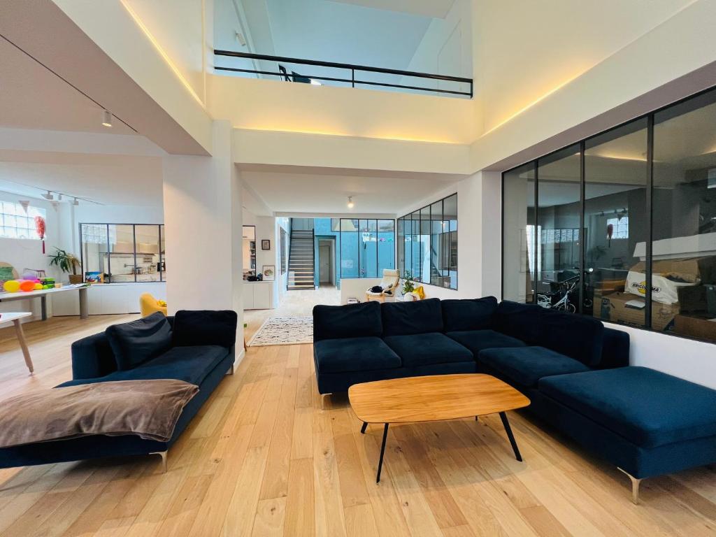 - un salon avec un canapé bleu et une table dans l'établissement LOFT Triplex 300m² à 10 min PARIS/EXPO, à Malakoff