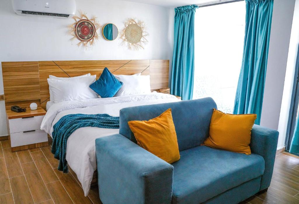 a bedroom with a bed and a blue couch at Vogue Beach Resort in Lagos