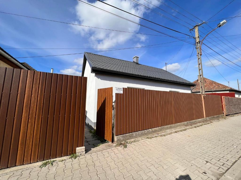 una casa con una valla de madera junto a una entrada de ladrillo en Csokonai Apartman, en Salgótarján