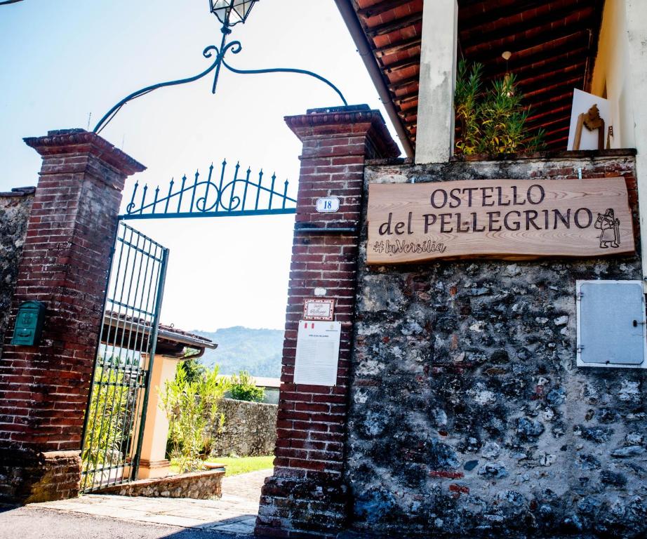um sinal na lateral de um edifício com um portão em Ostello di Camaiore em Camaiore