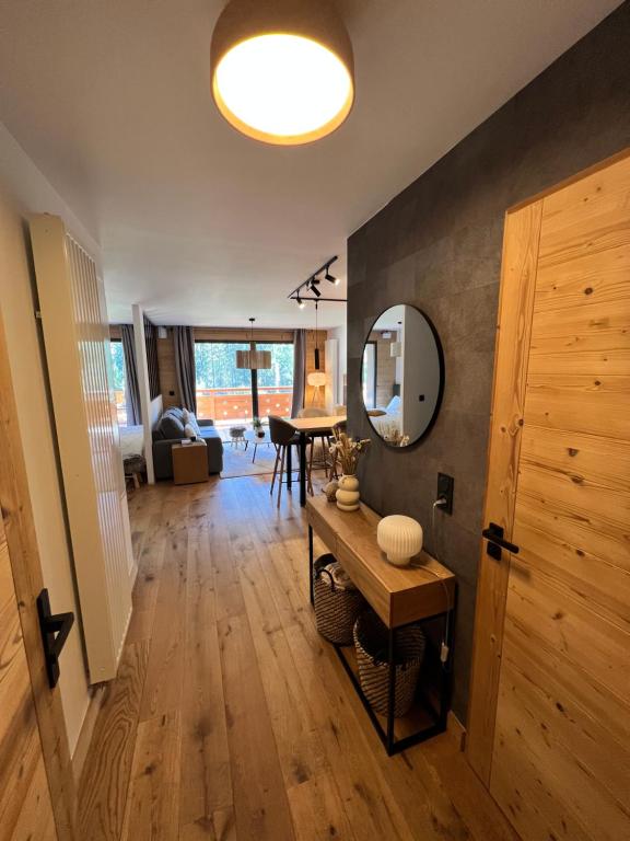 - un salon avec une table et un miroir dans l'établissement Très bel appartement au gets, aux Gets