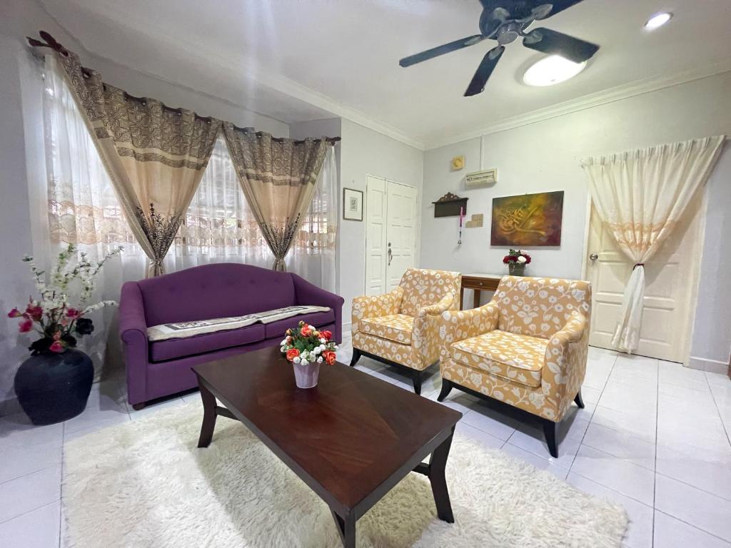 盧穆特的住宿－Venice Raudhah Guest House，客厅配有紫色沙发和桌子