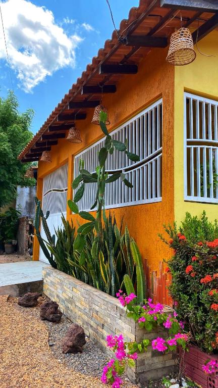 a yellow house with flowers in front of it at Casa Amarela Alter in Alter do Chao