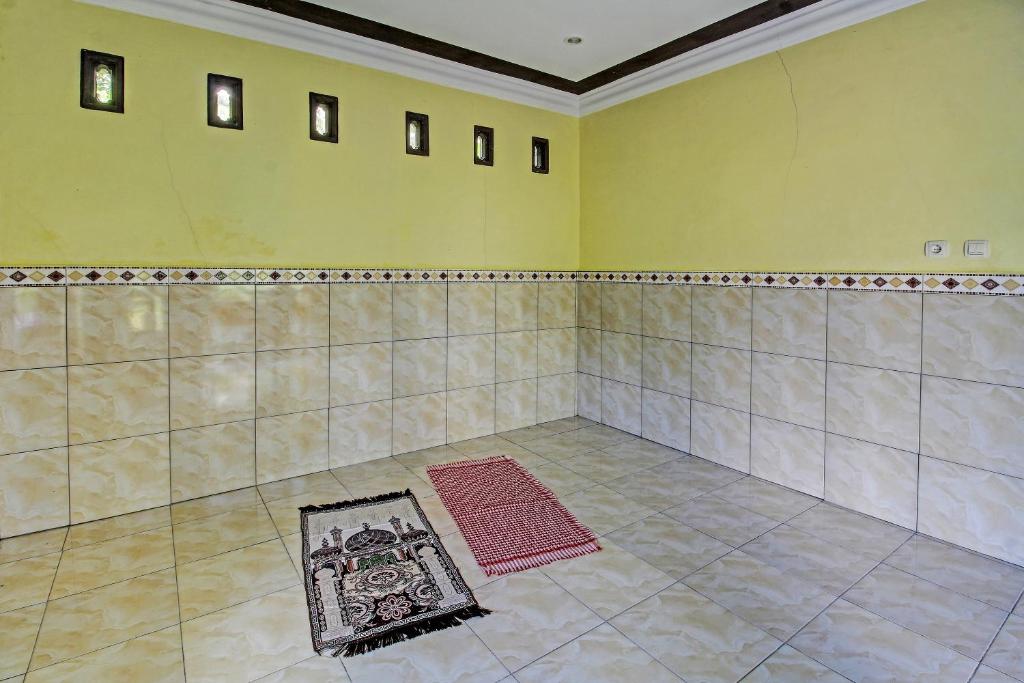 um quarto vazio com um quadro no chão em OYO 91177 Desa Wisata Duren Sari em Tasikmadu