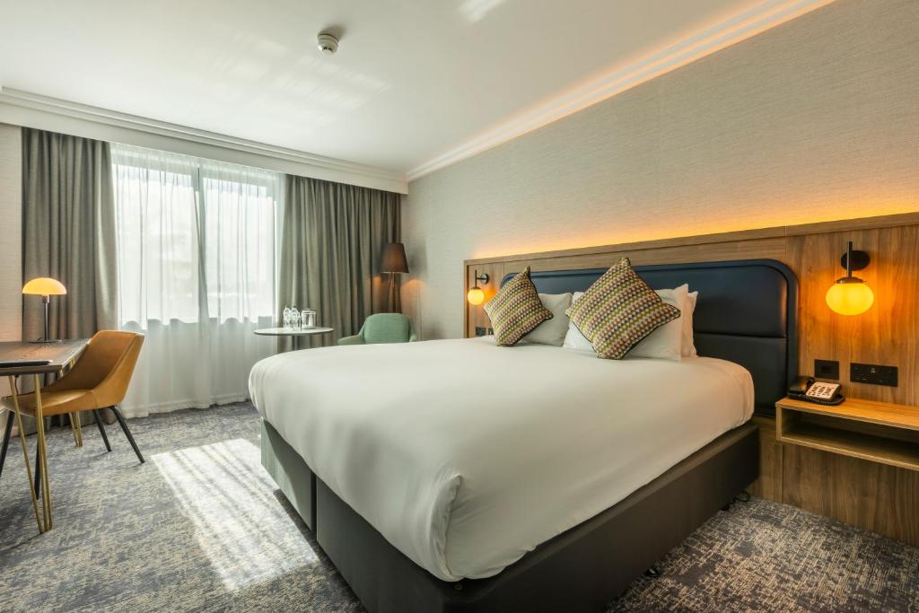 um quarto de hotel com uma cama grande e uma secretária em Crowne Plaza Manchester Airport, an IHG Hotel em Hale