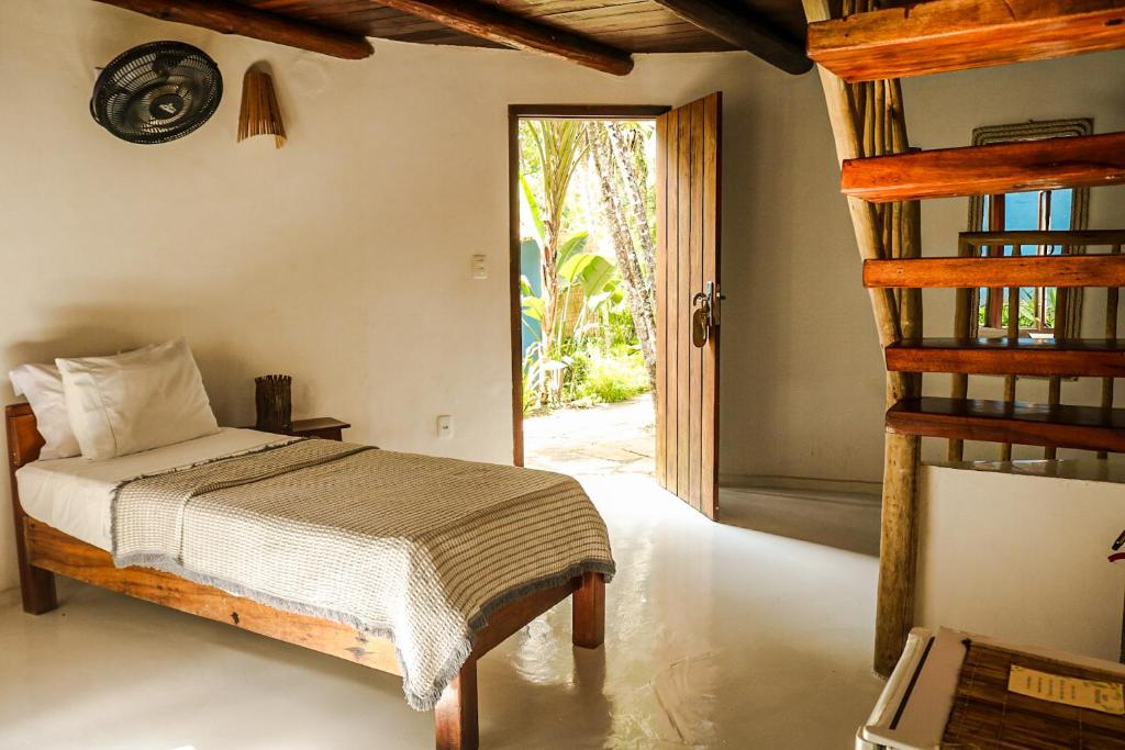 a bedroom with a bed and an open door at Pousada Jacarandá by Rivaj in Trancoso