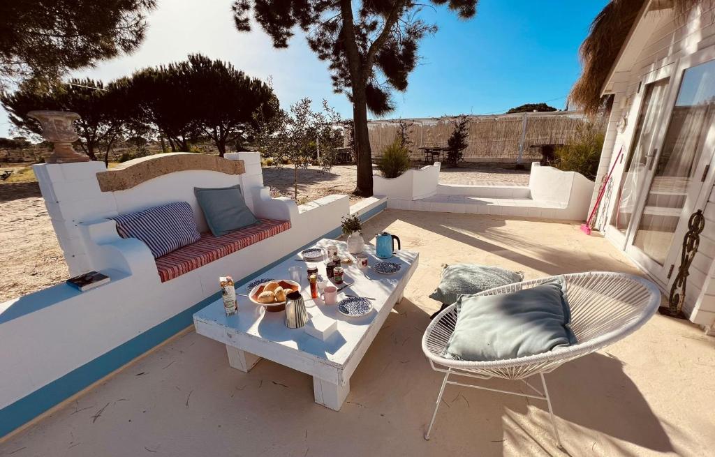 a patio with a couch and a table and chairs at Casa Paloma in Comporta