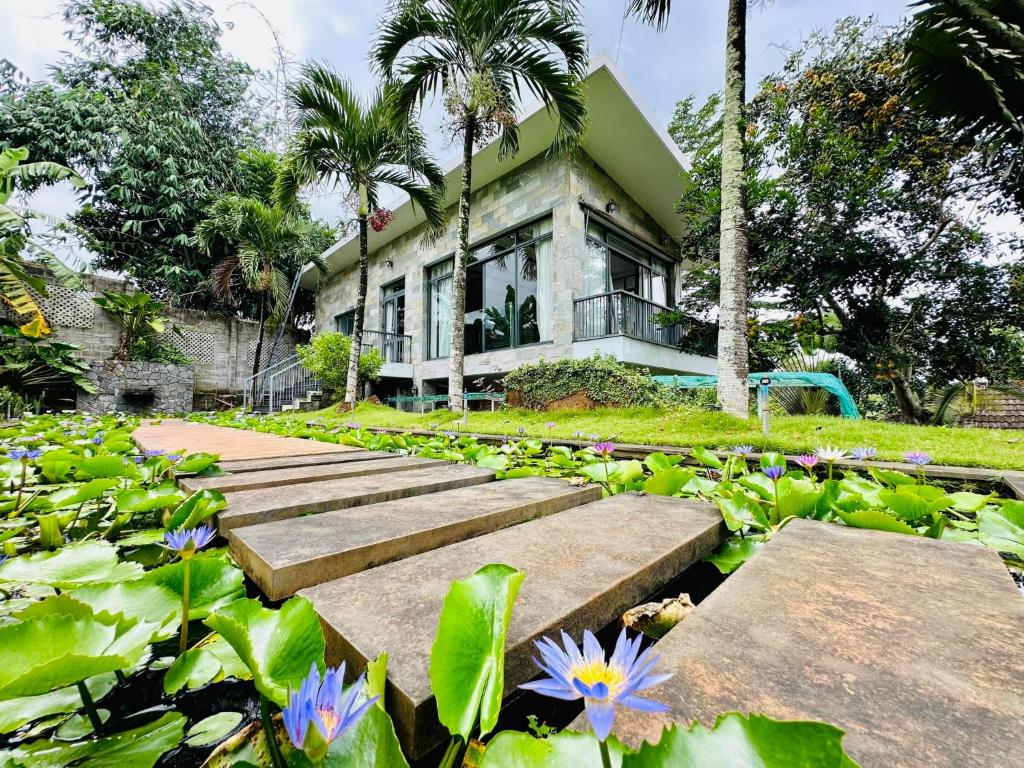 ein Haus in einem Garten mit Blumen und Blättern in der Unterkunft Chang House BMT 