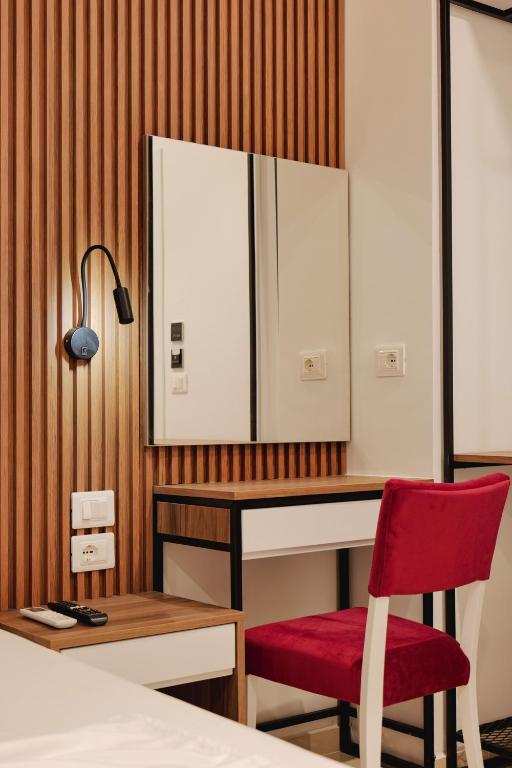 a bedroom with a desk and a red chair at Vila Shpetimi in Ksamil