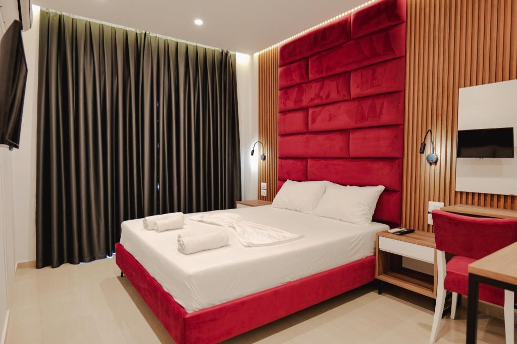 a bedroom with a large bed with a red headboard at Vila Shpetimi in Ksamil