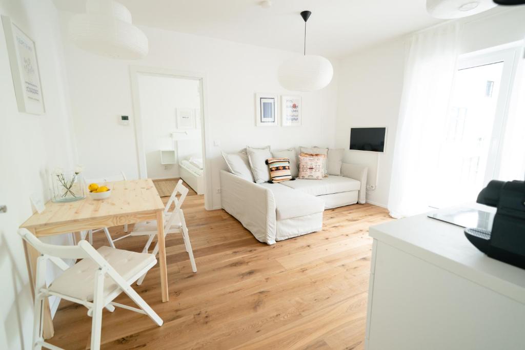 ein weißes Wohnzimmer mit einem Tisch und einem Sofa in der Unterkunft Apartment Seekind by Cosy Homes in Reifnitz